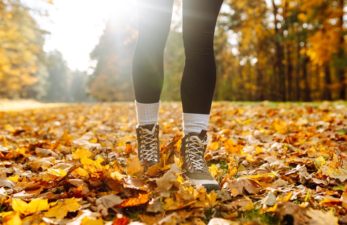 A female walking on autumn leaves